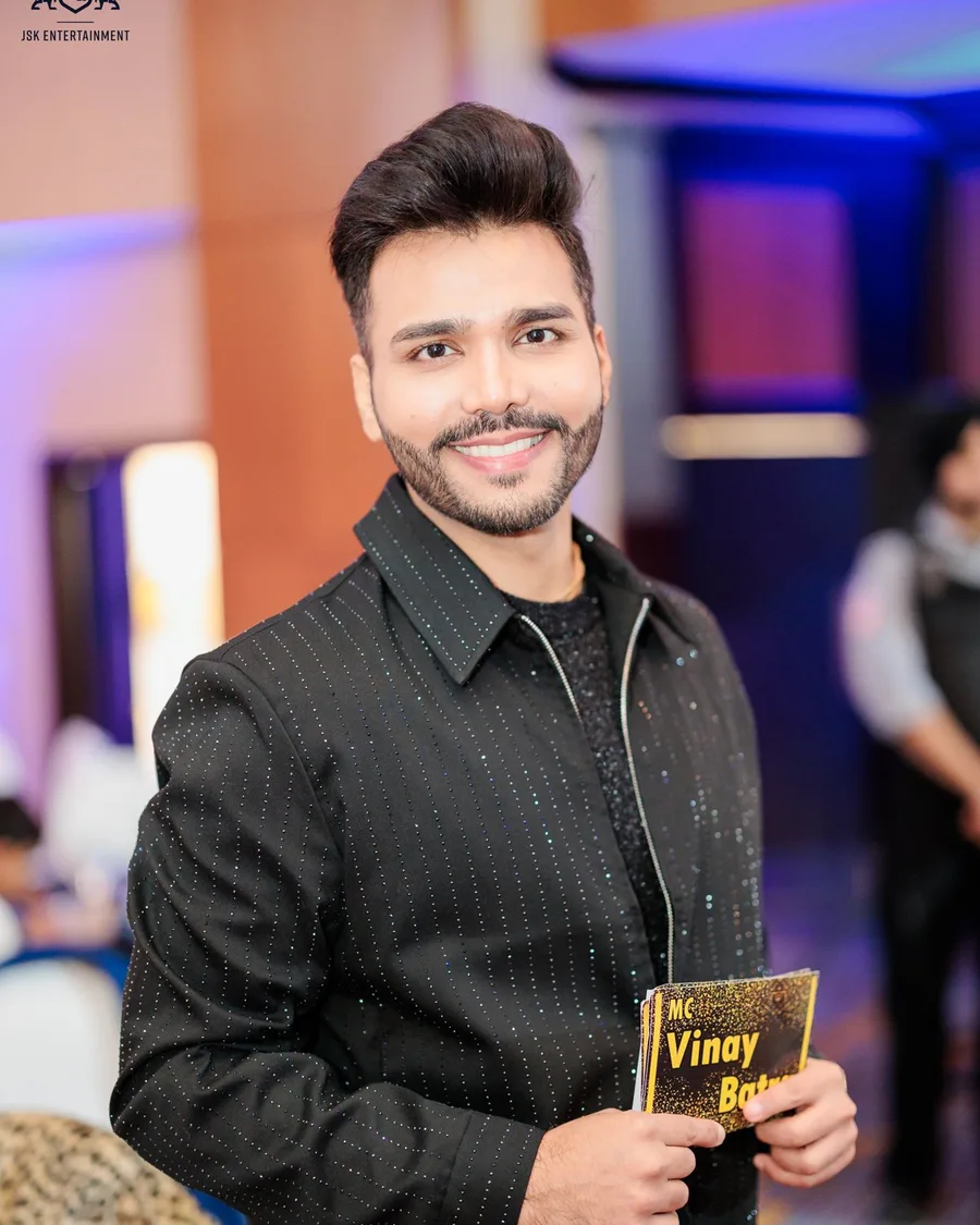 Portrait of Vinay Batra holding his MC cue card